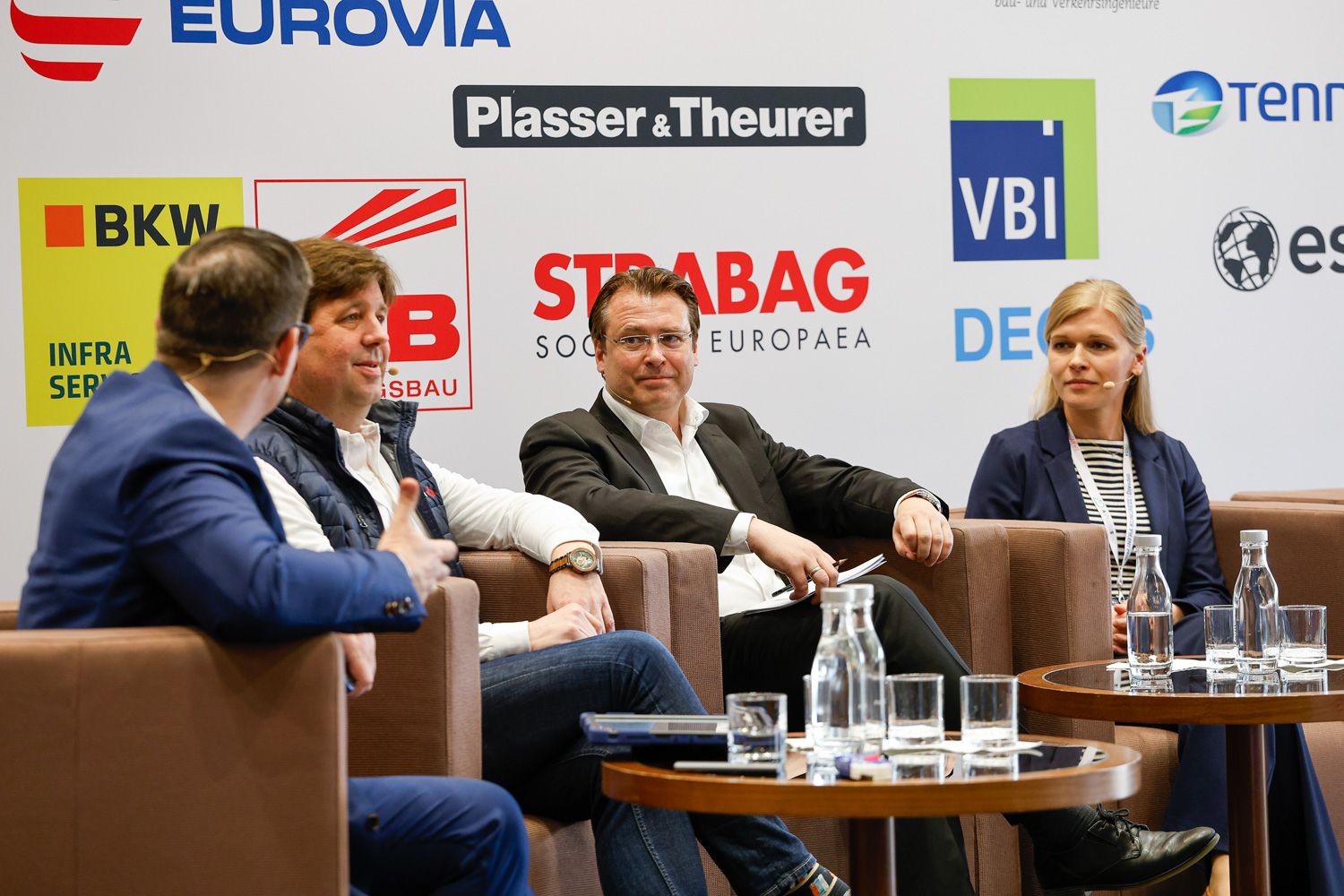 Podiumsdiskussion vor den Logos der Sponsoren