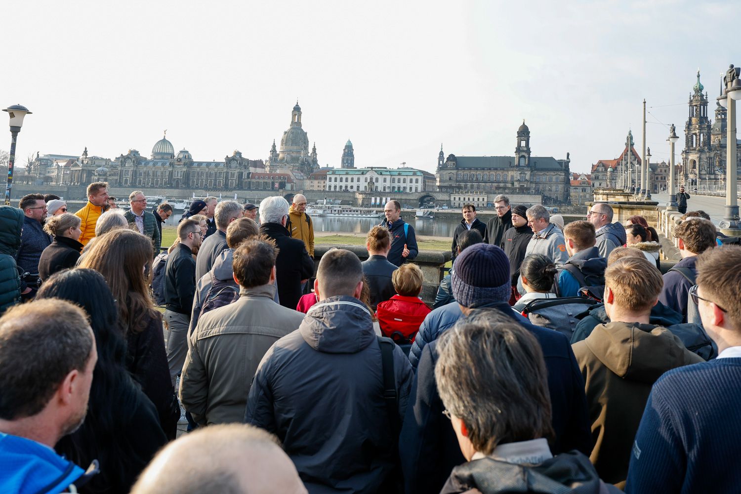 Teilnehmende am Elbufer, im Hintergrund die Altstadt